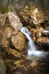 Obraz premium Autumn forest scene with a waterfall and many rock formations