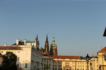 Fototapeta premium The iconic towers of Prague Castle and the magnificent St. Vitus Cathedral stand proudly against a clear blue sky in the beautiful city of Prague, located in the Czech Republic