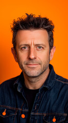 Fototapeta premium happy, studio portrait of a man in his 30s, front mugshot, looking at the camera, facing the camera straight ahead, random clothes. orange style. vertical composition