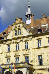 Fototapeta premium One of the calling cards of the Old Town of Sighisoara (Romania): the City Hall building. Transylvanian Baroque style: the facade of the administrative building with a pediment and a turret.