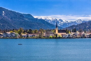 Blick auf das Ufer von Rottach-Egern und die Kirche St. Laurentius. Im Hintergrund die verschneiten...