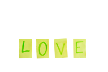 The word love is written in green letters on a white background. The letters are cut out of yellow paper and arranged in a row. Concept of warmth and affection