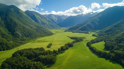 Obraz premium Aerial View of Lush Green Valley Surrounded by Majestic Mountains