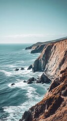 Obraz premium A stunning view of the rugged coastal cliffs meeting the tranquil ocean under a clear sky at dusk