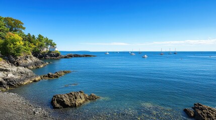 Obraz premium Serene coastline view with gentle waves, anchored boats, and vibrant greenery on a clear sunny day