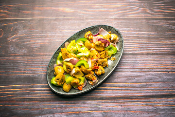 Sauteed Mushroom with vegetables, onion and capsicum served in tray dish isolated on wooden table top view of bangladeshi and thai food