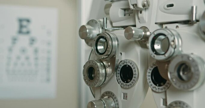 Close-Up of Phoropter: Eye Exam Equipment and Eye Chart in Optometrist's Office