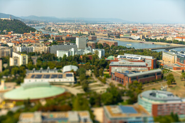 Naklejka premium Budapest, Hungary - August 24, 2024: Panoramic View Over Budapest's Landmarks and Danube River. Focus shifted to the river with tilt shifted lens.