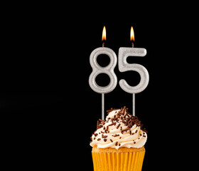 Number 85 shaped candles - Birthday cupcake on black background.