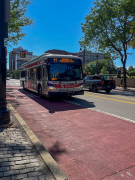 A red and white bus is driving down a street