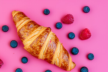 A croissant with berries and raspberries on a pink background. A croissant with berries and a pink background. Croissant berries pink background sweetness berry. A croissant with a lifestyle berry on.