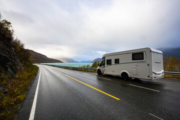 Obraz premium A motorhome parked by the road in the autumn landscape of the Lyngen Alps, Northern Norway, with mountains.