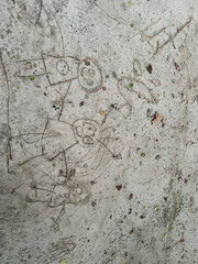 Child's imaginative drawing etched into concrete surface outdoors