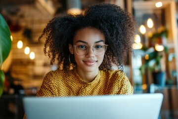 Focused student working on laptop in cozy coffee shop setting urban environment portrait style remote learning concept
