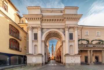 Savigliano, Italy: Triumphal Arch (16th cent.) at the beginning of via Sant Andrea with a view of the bell tower of the church of San Andrea