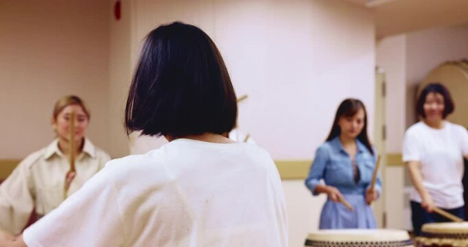Taiko, rhythm or people with music drum in studio for performance practice or cultural rehearsal in Japan. Tradition, women band or teacher with bachi percussion demonstration for sound entertainment