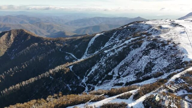 Aerial view of Mount Buller ski resort in winter, showing snow-covered mountain scenery and numerous skiers on the slopes