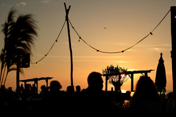 People relax and enjoy the sunset on the Beach Club. 