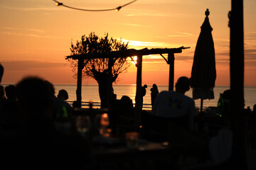 People relax and enjoy the sunset on the Beach Club.