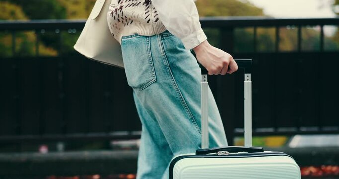 Suitcase, travel and legs of woman walking outdoor for vacation, holiday and commute on journey to Japan. Luggage, hand and passenger on trip with bag for tourism, destination and leaving location