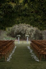 Elegant wedding venue with brown wooden chairs surrounding a decorated path
