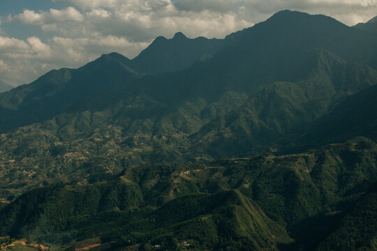Stunning view from the peak of Fansipan Mountain in Lai Chau, Vietnam, showing clouds rolling over the lush green mountains