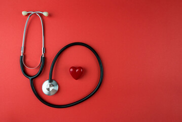 red heart and stethoscope on red background.