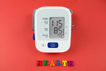 Electronic tonometer on a red background. The concept of cardiovascular diseases.