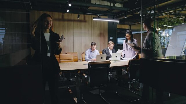 A collaborative meeting in a modern office a group of people finish their working day and leave the office, one person remains to work alone
