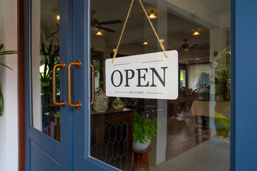welcoming open sign hangs on blue door, inviting customers inside