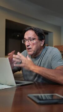 A man working at home uses his laptop to get bad news, perhaps in an email. Or maybe his computer or hard drive crashed, or he lost or accidentally deleted all his data files. Vertical orientation.  	