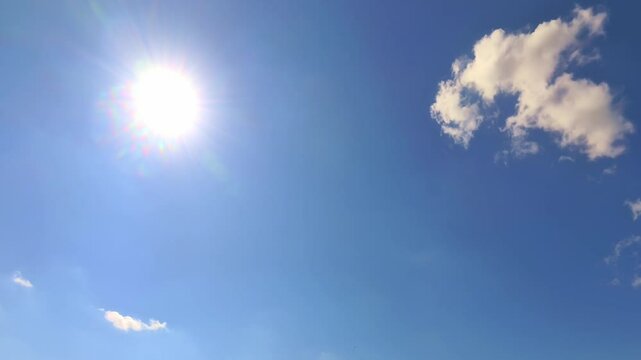gro&szlig;e hell strahlende Sonne an blauem Himmel mit kleiner Wolke, Solarenergie, UV-Strahlung, Wetter, Klima, Sommerwetter, Natur, Klimawandel, Photovoltaik, Hitze, UV-Strahlen