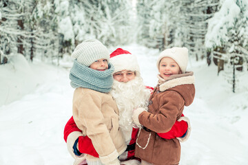 Obraz premium Santa Claus with children in a snowy forest.