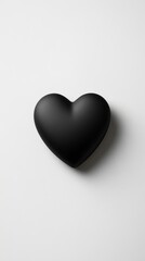 Obraz premium A single black heart with matte finish isolated on a white background with copy space.