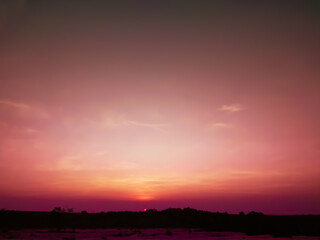 Sunset scenery, tiny clouds spread across the vast sky. It enhances the serene atmosphere of the...