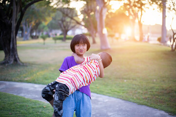 Cute children play in the park at sunset.