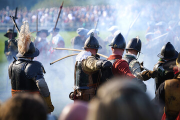 Pikemen with long wooden peaks in the attack on a battle scene during historical cosplay