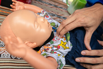 Práctica de reanimación cardio pulmonar en muñeco con forma de bebé - Cardiopulmonary resuscitation practice on a baby-shaped doll