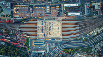 Aerial view of large parking lot with cars in Krakow, Poland. Railway station with trains, rails...