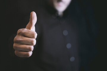 Closeup Of Male Hand Showing Thumb Up Or Like Gesture. Young Business Man On Black. Studio Light, Selective Soft Focus. Copy Space Background