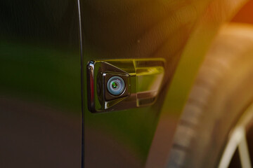 Car side fender with blind spot monitoring lens closeup. Car advanced side view camera system...