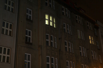 A captivating nighttime view showcases a residential building, where illuminated windows create a...
