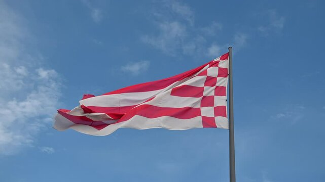 Flag of Bremen  flying in the wind with a blue sky background..