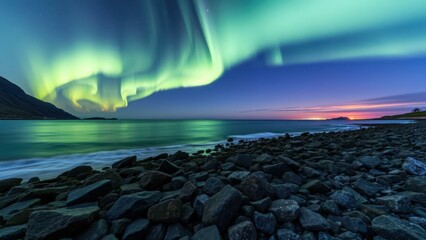 Obraz premium Experience the Majestic Northern Lights Illuminating the Night Sky Over a Rocky Beach at Dusk