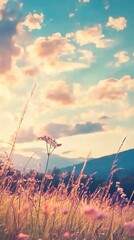 Obraz premium A serene landscape with mountains, clouds, and wildflowers at sunset.