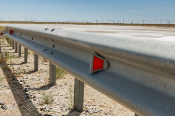 red road reflectors along the road. metal road fencing. Road and traffic safety