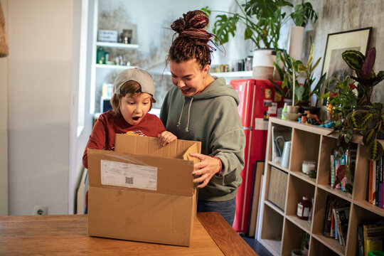 Mother and son opening delivery package at home