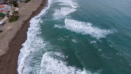 Aerial Coastal Paradise: Sandy Beach, Vibrant Palm Trees, and Deep Blue-Green Ocean Waves Captured from Above. Ideal for travel, vacation, seaside, and nature-inspired projects.