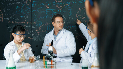 Smart teacher explain about chemical theory while student mixing colored solution or doing...