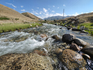 Stream in the mountains in summer. Beautiful clouds in the sky. Vivid photographs of natural...